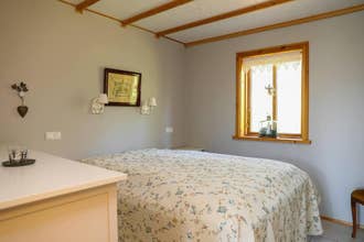 Knusse slaapkamer met bloemenbeddengoed in Heidarsel Cabin nabij Akureyri.