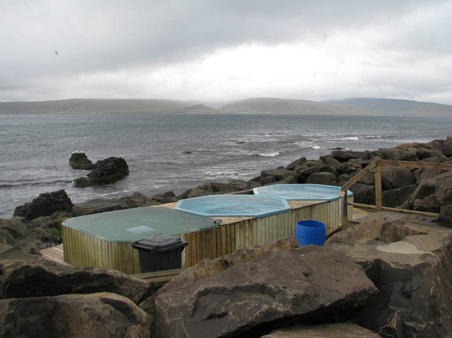 Trois bains chauds habillés de bois sur le littoral rocheux de Drangsnes, face à Steingrimsfjordur. Trois bains chauds habillés de bois sur le littoral rocheux de Drangsnes, face à Steingrimsfjordur.