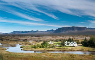 Les bâtiments blancs et les paysages du parc national de Thingvellir.