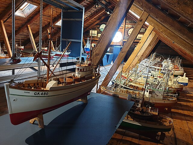 Model fishing boats displayed in glass cases at the Reykjanes Maritime Museum in Iceland.