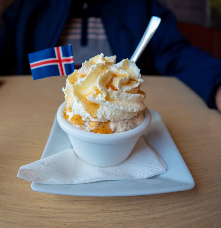 Traditional Icelandic Skyr dessert with whipped cream and caramel drizzle, served in a white bowl with a small Icelandic flag.