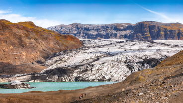 Traavelers exploring the icy terrain of Solheimajokull Glacier in South Iceland.