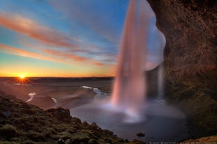 Seljalandsfoss Waterfall in South Iceland viewed from the walking path behind the cascade.