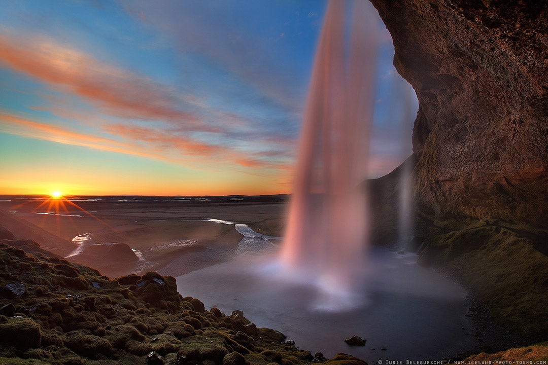 The cascade of Seljalandsfoss Waterfall taken from the side of the waterfall.