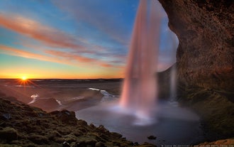 The cascade of Seljalandsfoss Waterfall taken from the side of the waterfall.