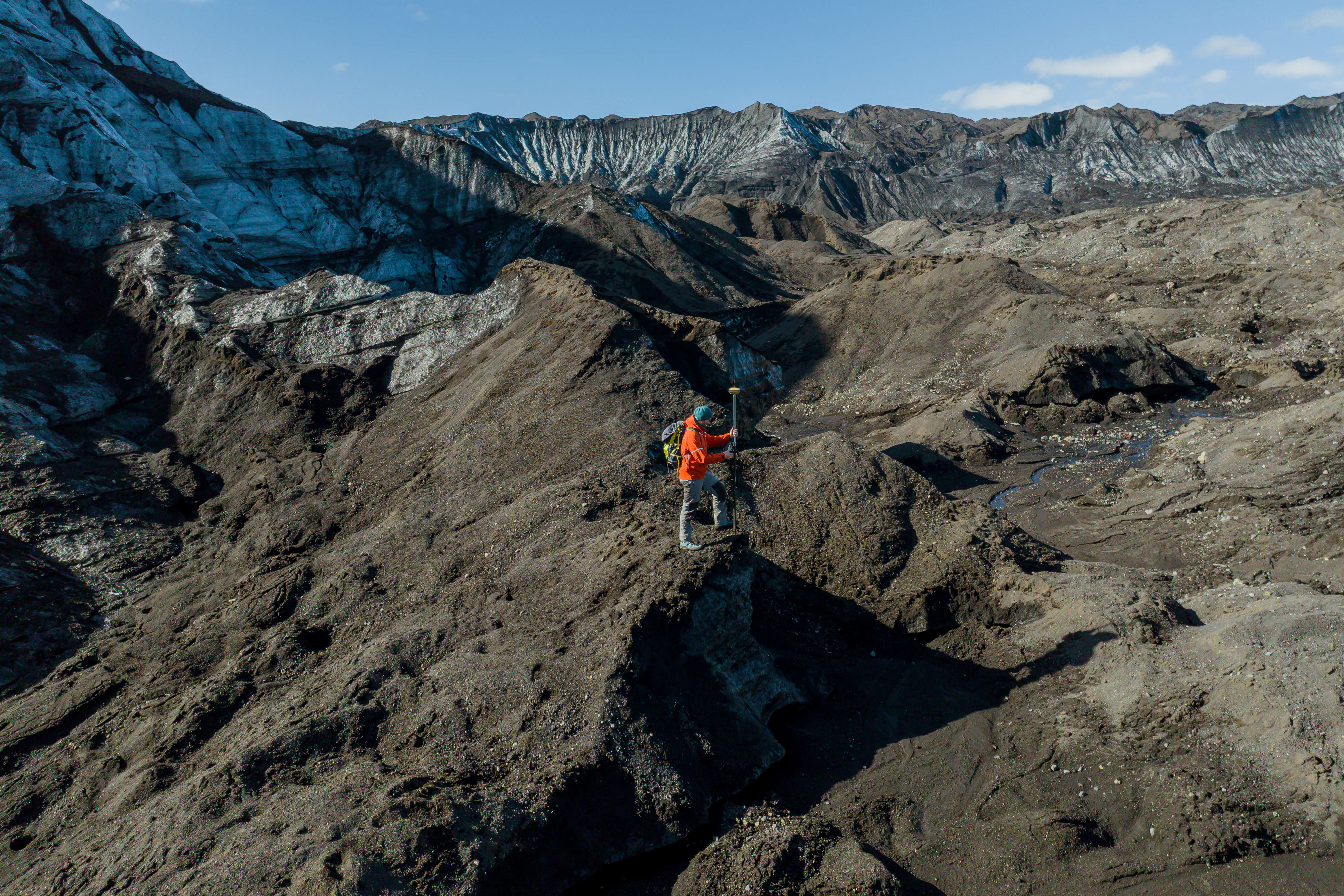 A researcher maps ice formations during the Ice Mapping Expedition at Katla Glacier in Katla Geopark on a clear summer day.