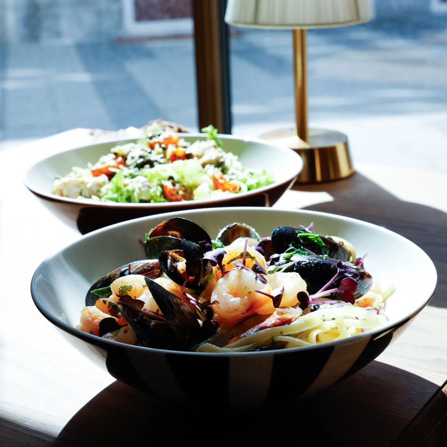 Délicieuse assiette de pâtes aux fruits de mer avec moules, crevettes, herbes fraîches et salade colorée servie chez Froken Selfoss. Délicieuse assiette de pâtes aux fruits de mer avec moules, crevettes, herbes fraîches et salade colorée servie chez Froken Selfoss.