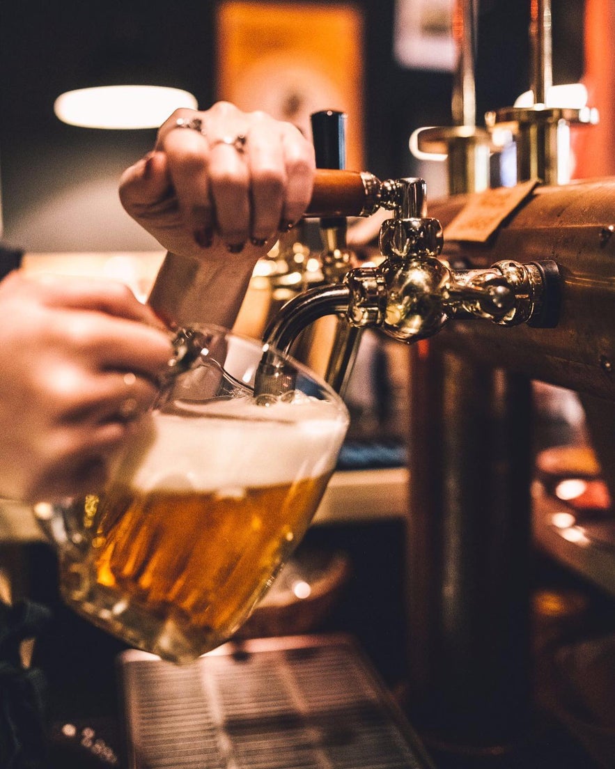 Barman servant une bière fraîche et mousseuse chez Tommi's Burger Joint à Selfoss, Islande. Barman servant une bière fraîche et mousseuse chez Tommi's Burger Joint à Selfoss, Islande.