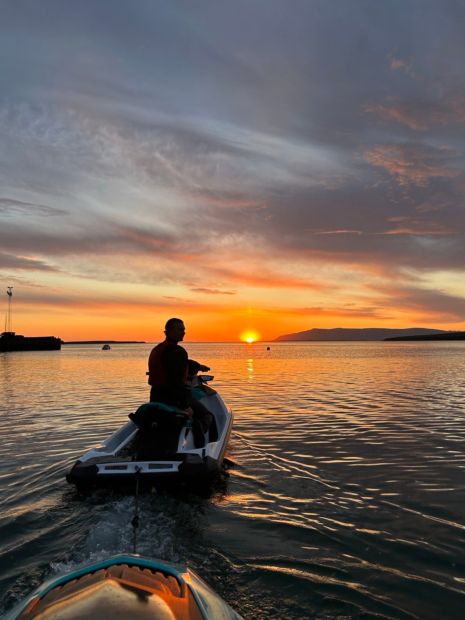 Person on a jet ski watching the sunset over Faxafloi Bay near Reykjavik.