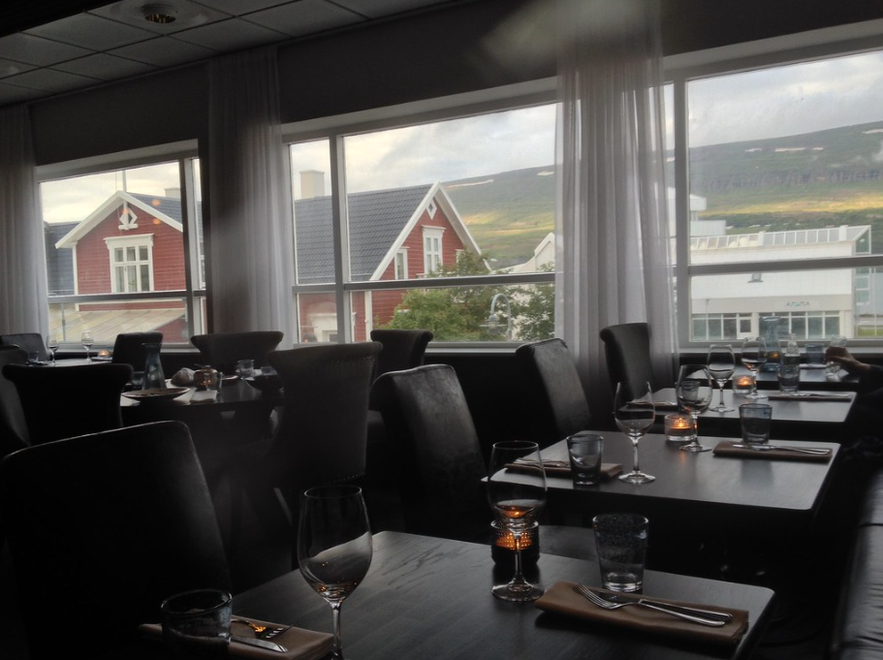 Cozy dining at Mulaberg Bistro & Bar, a top-rated restaurant in Akureyri with views of Icelandic homes.