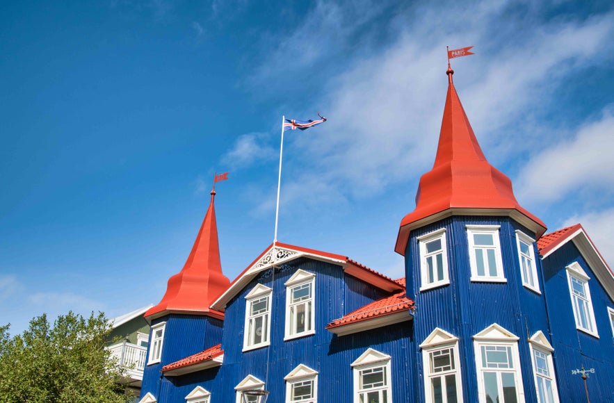 Bright blue Bláa Kannan Café with red spires, a top spot for brunch in central Akureyri, Iceland.