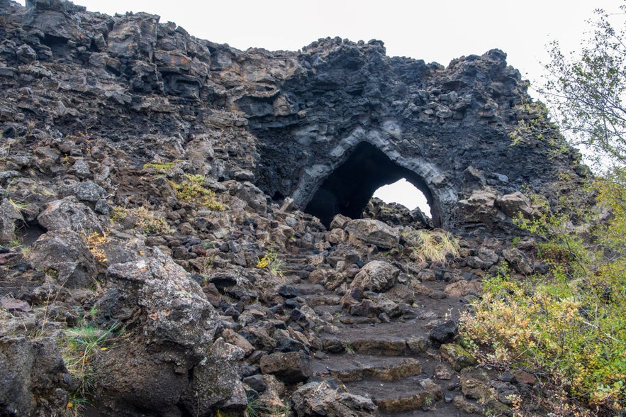 Lava rock archway known as the Church at Dimmuborgir in North Iceland, surrounded by volcanic formations and mossy stones