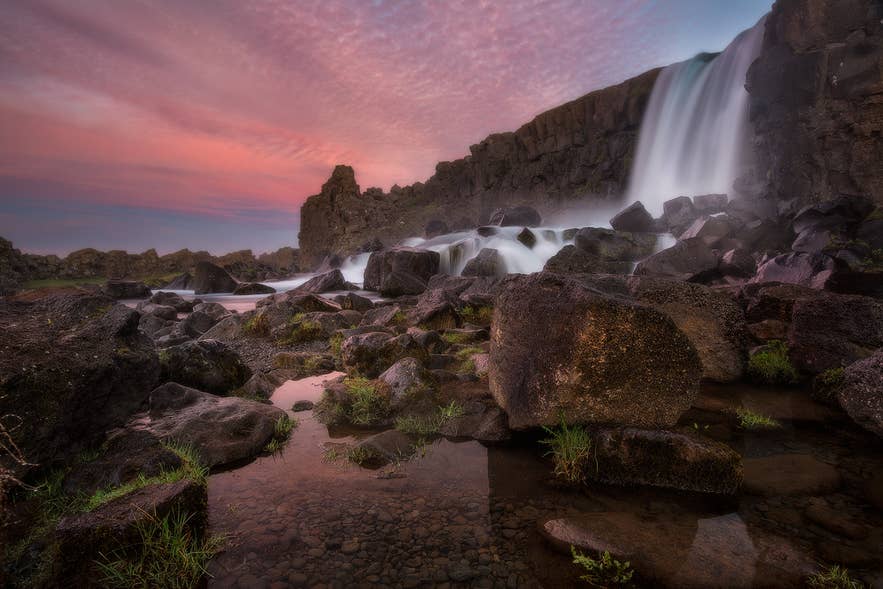 La cascata Oxararfoss che scende sulle rocce vulcaniche in estate al tramonto nel Parco Nazionale di Thingvellir, nel sudovest dell'Islanda