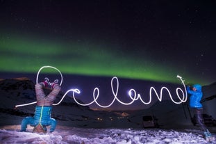 A pair playing with the light during their northern lights hunting tour from Akureyri.