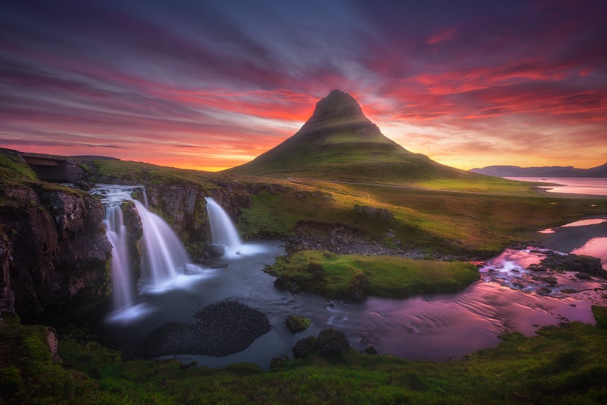 Un atardecer dorado ilumina la Montaña Kirkjufell y las cascadas gemelas de Kirkjufellsfoss en el oeste de Islandia. Un atardecer dorado ilumina la Montaña Kirkjufell y las cascadas gemelas de Kirkjufellsfoss en el oeste de Islandia.