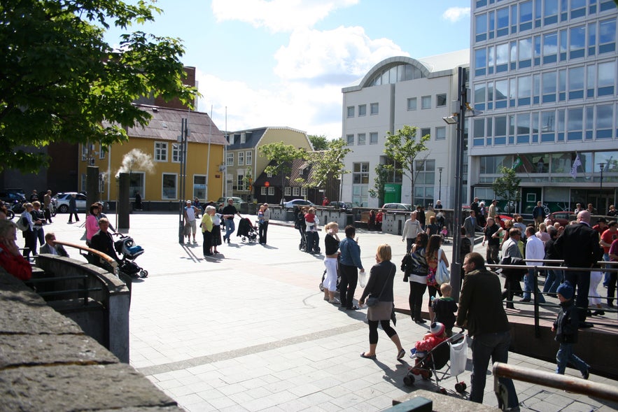 Locals and tourists strolling in Ingolfstorg square in Reykjavik.