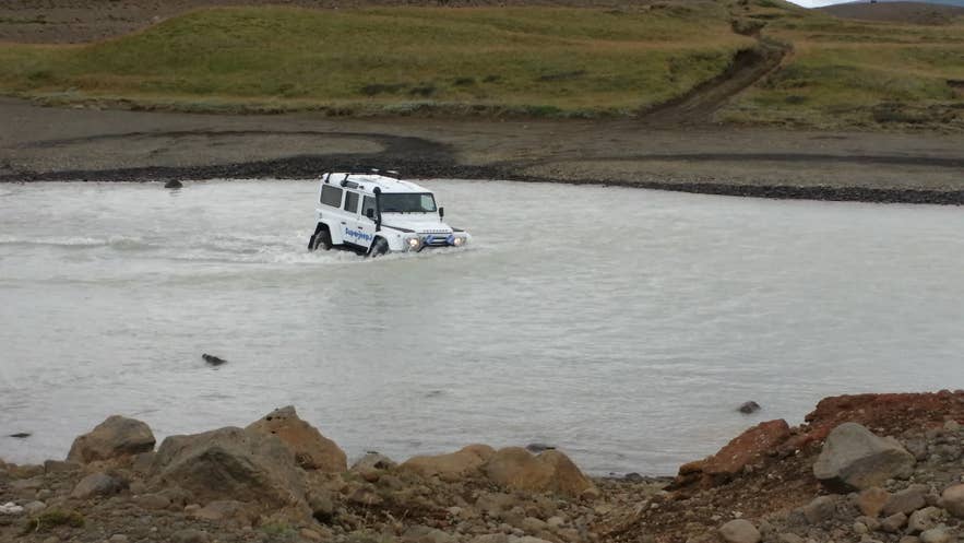 Rental 4x4 safely crossing a mountain river on an Iceland F-road.