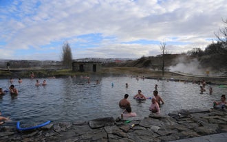 A group of bathers enjoy the warm waters and gorgeous surroundings of the Secret Lagoon hot spring.