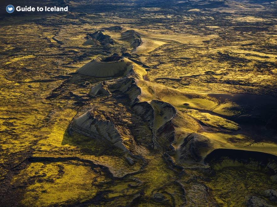 Luchtfoto van de vulkanische kraters van Lakagigar in de zuidelijke hooglanden van IJsland, bedekt met levendig groen mos en omringd door indrukwekkende lavavelden.