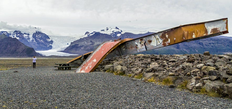 Remains of a twisted steel bridge destroyed by glacial flood (jökulhlaup) near Skaftafell National Park with Vatnajokull glacier in the background.