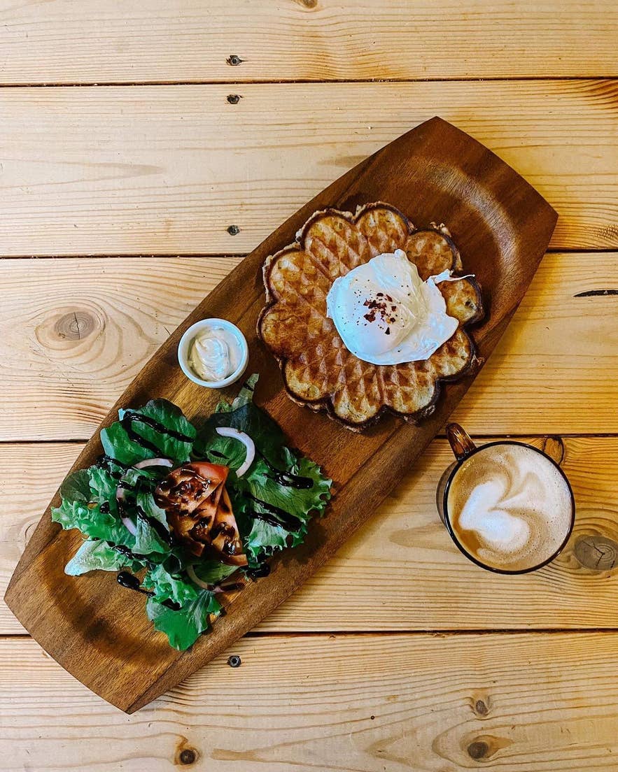 A huge plate of waffles with salad on the side served with a cup of coffee in Heimabyggd, Isafjordur, West Iceland