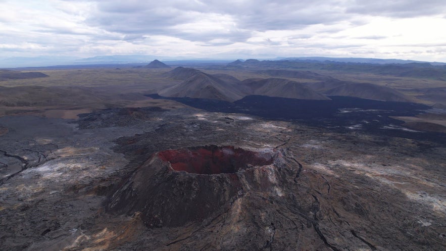 Fagradalsfjall volcano crater surrounded by solidified lava fields on Reykjanes Peninsula, Iceland, aerial view of volcanic landscape after 2021 eruption.