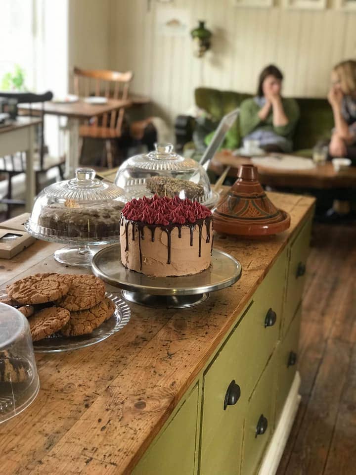 An assortment of cookies on multiple plates and a whole cake inside Simbahollin in Thingeyri