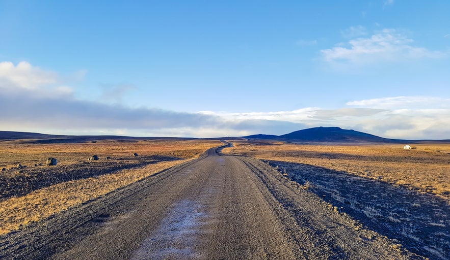 Gravel road on Kjolur Highland Route F35 through Iceland’s volcanic landscape.