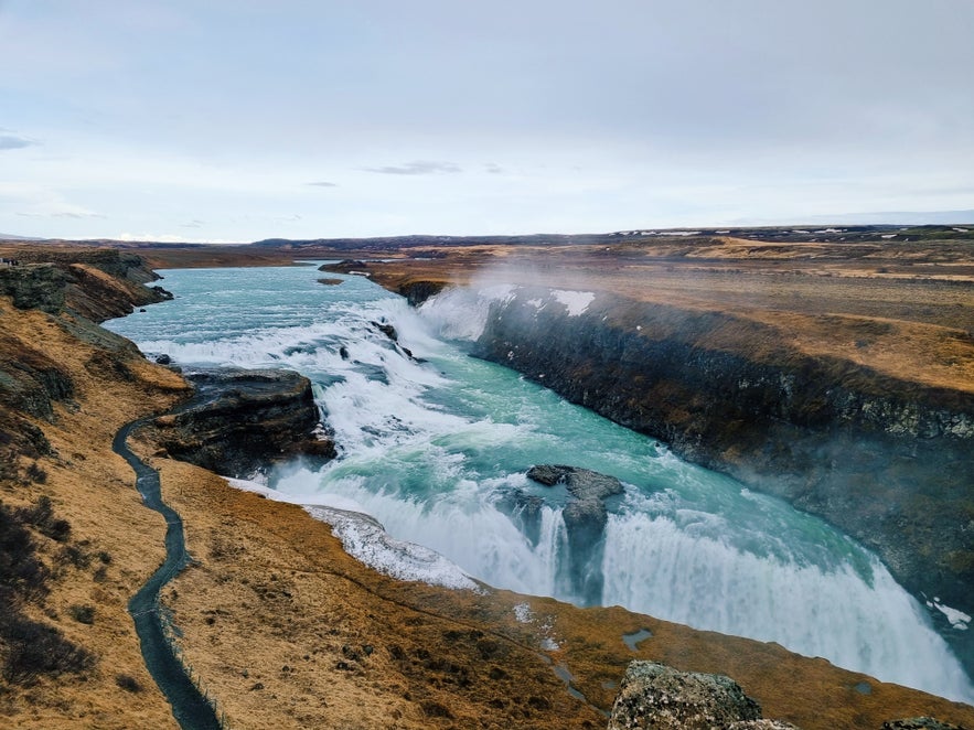 Gullfoss Waterfall in Iceland with turquoise water rushing through a rugged canyon.