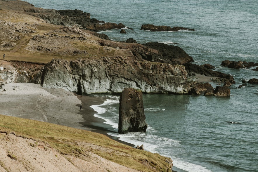 Coastal rock formations and black-sand shoreline at Fauskasandur Beach in South Iceland.