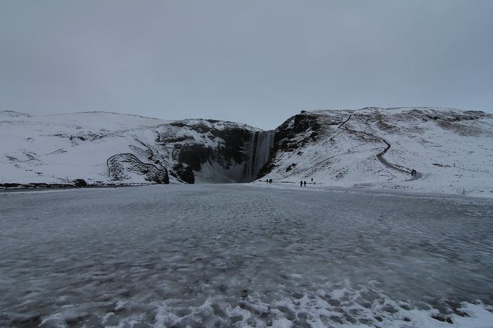 Skogafoss waterfall transforms into a snow wonderland during winter.