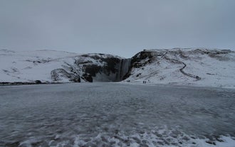 Skogafoss waterfall transforms into a snow wonderland during winter.