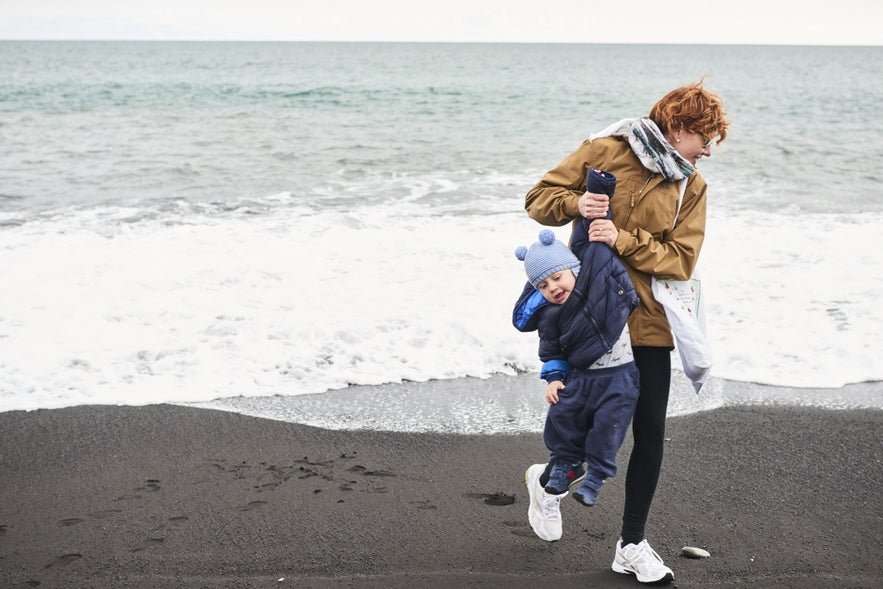 A mother and child on a beach by Grotta lighthouse