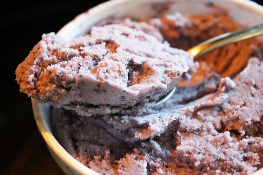 Thick blueberry skyr in a small ramekin and on a spoon.