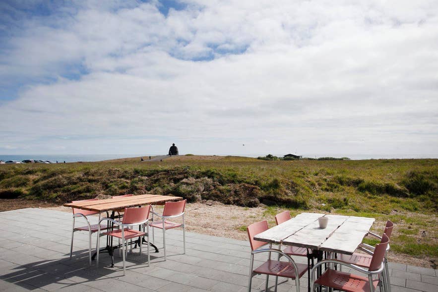Arnarbaer Restaurant's outdoor patio with empty tables and chairs overlooking a grassy landscape. Arnarbaer Restaurant's outdoor patio with empty tables and chairs overlooking a grassy landscape.