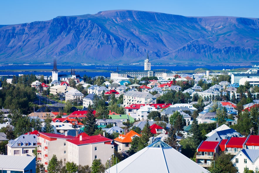 Beautiful super wide-angle aerial view of Reykjavik, Iceland with harbor and skyline mountains and scenery beyond the city, seen from the observation tower of hallgrimskirja