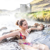 Una mujer se relaja en las aguas termales de Reykjadalur.