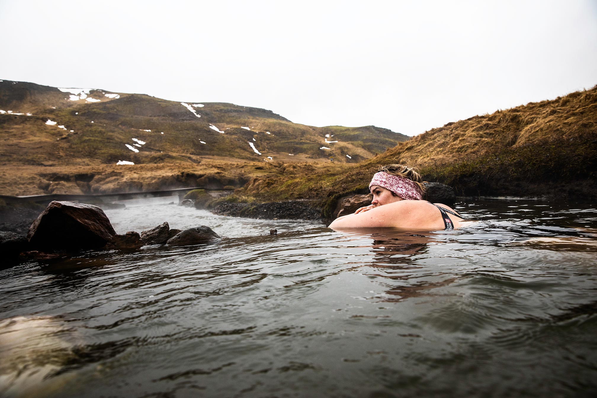 Reisende genießen die heißen Quellen von Reykjadalur mitten in der Natur.