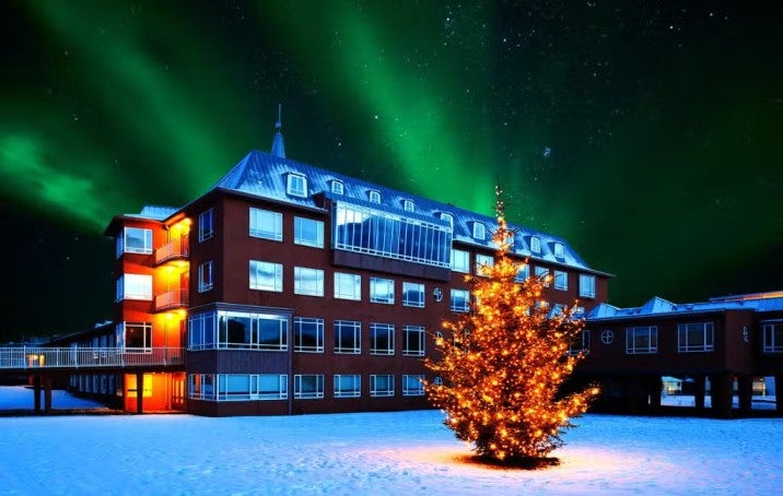 Facade of Hostel B47 under northern lights in Reykjavik, Iceland.