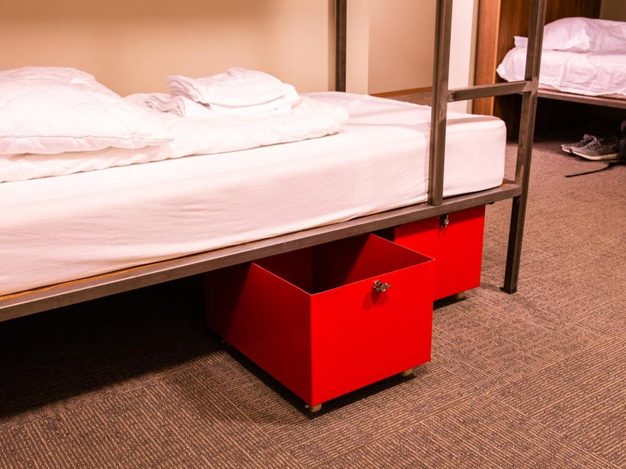 Extra storage under a bunk bed at Reykjavik Loft HI Eco Hostel in Iceland.