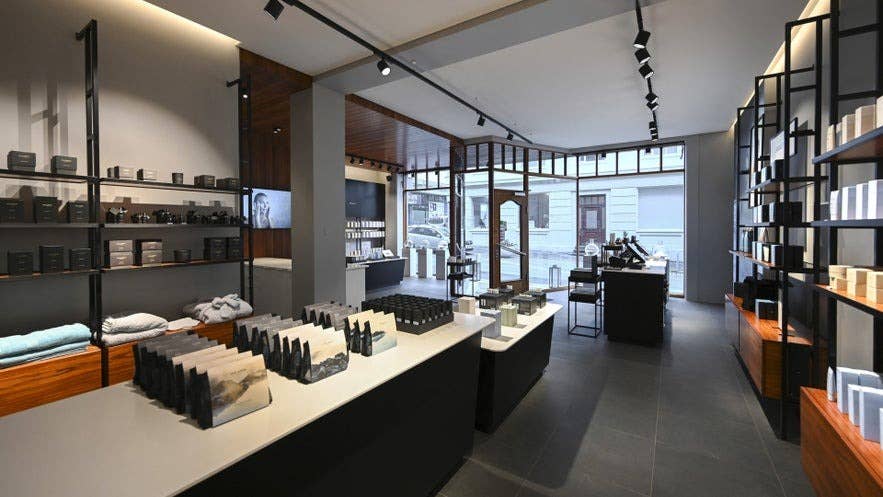Interiøret i Blue Lagoon Skincare-butikken i Reykjavik, Island, præget af et elegant, minimalistisk design med pænt udstillede hudplejeprodukter, bløde håndklæder og naturligt lys fra de store vinduer mod gaden.