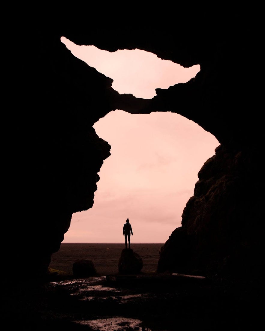 Silhouette of a person standing at the entrance of Yoda Cave in Iceland.