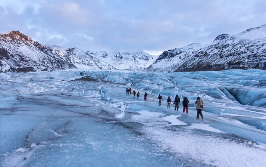 Glacier hike in Skaftafell with views of Vatnajokull and snow-covered mountains in South Iceland.