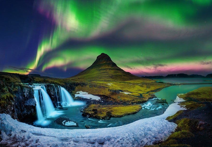 Northern lights over Kirkjufell mountain and Kirkjufellsfoss waterfall in West Iceland.