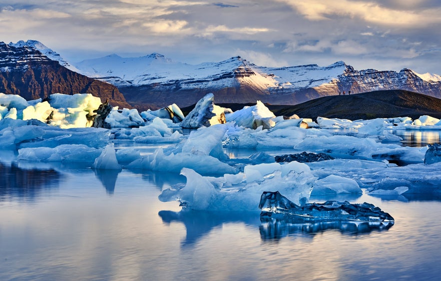 Icebergs floating in Jokulsarlon Glacier Lagoon with mountains in South Iceland.