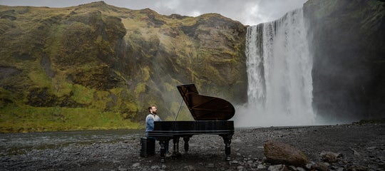 A pianist in front of Skogafoss Waterfall in Iceland..jpg
