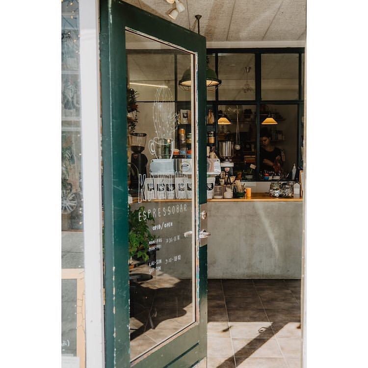View through the front door into Kaktus Espressobar, a cozy minimalist coffee shop in Reykjavik.