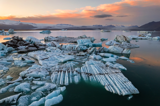 Chunks of ice broken off from icebergs float on Jokulsarlon Glacier Lagoon .