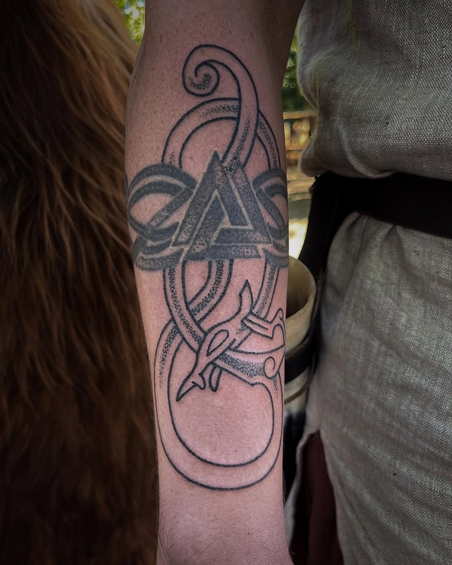 Hand-poked Viking-themed tattoo on an arm, featuring bold lines and Norse-inspired elements.