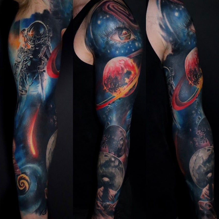 Colorful space-themed full sleeve tattoo featuring planets, a realistic astronaut, and twinkling stars.
